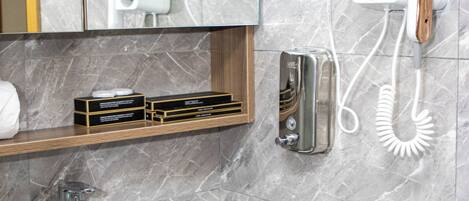A bathroom with a marble wall, a sink with a granite countertop, a mirror, a hairdryer, and a telephone.