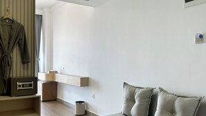 Un salon moderne avec un canapé, une table basse et un porte-manteau.