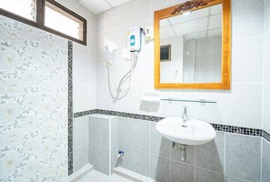 A bathroom with a shower, a sink, and a mirror.