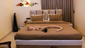 A neatly made bed with a brown cover, a bedside table, a lamp, and a wall decoration. - Green Wood Villa By 97RoyalVista (Mawal)