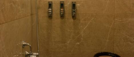 A bathroom with a shower, a window, and a towel rack.