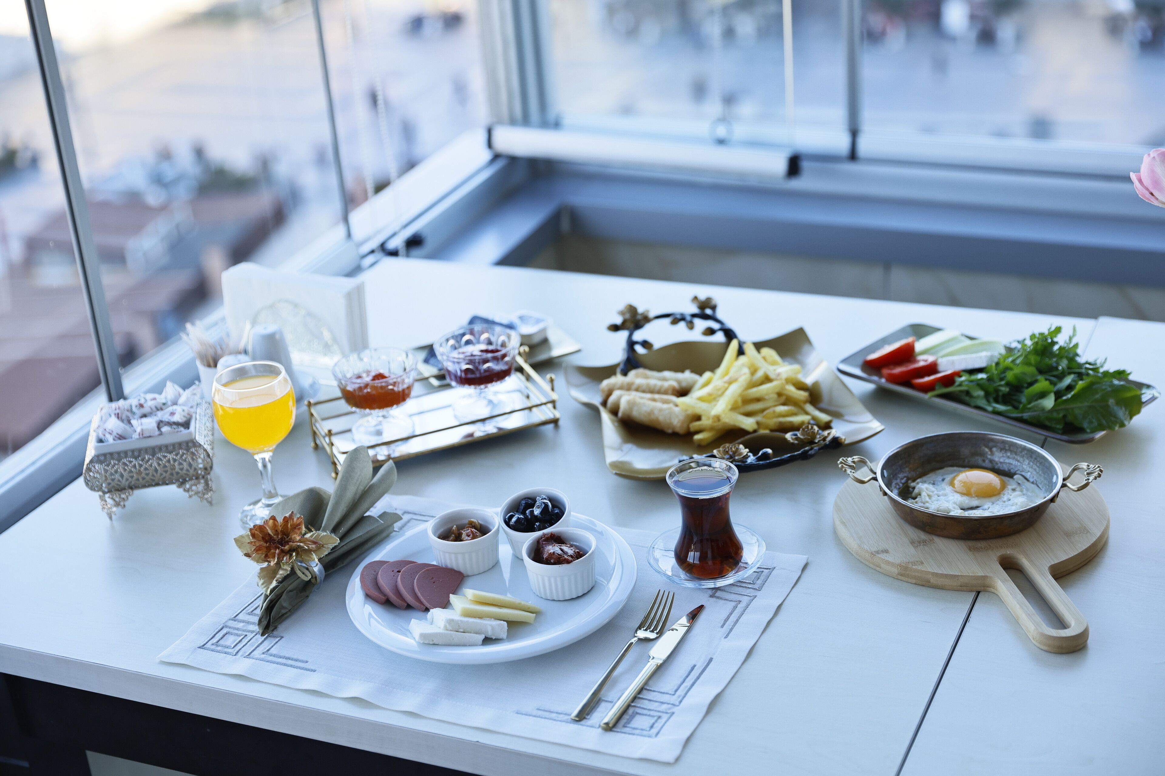 Una mesa con diferentes alimentos, incluyendo queso, carnes y un plato con huevo.