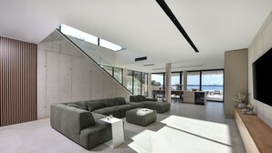 Una sala de estar moderna con un sofá modular, una mesa de centro y un televisor en la pared.