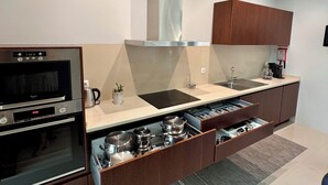A modern kitchen with built-in appliances, a stainless steel range, a microwave, and a sink. - Villa Branco in the North of Portugal (Barcelos)