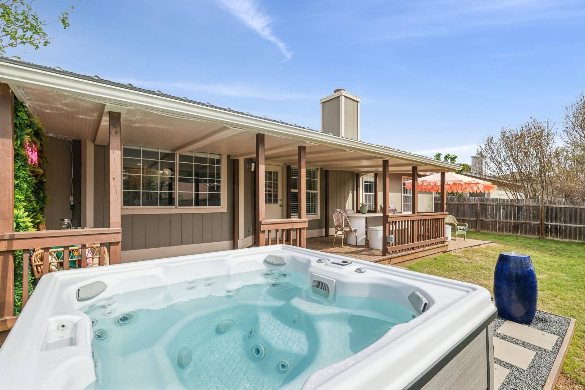 Ein Whirlpool mit Holzterrasse und überdachtem Patio.