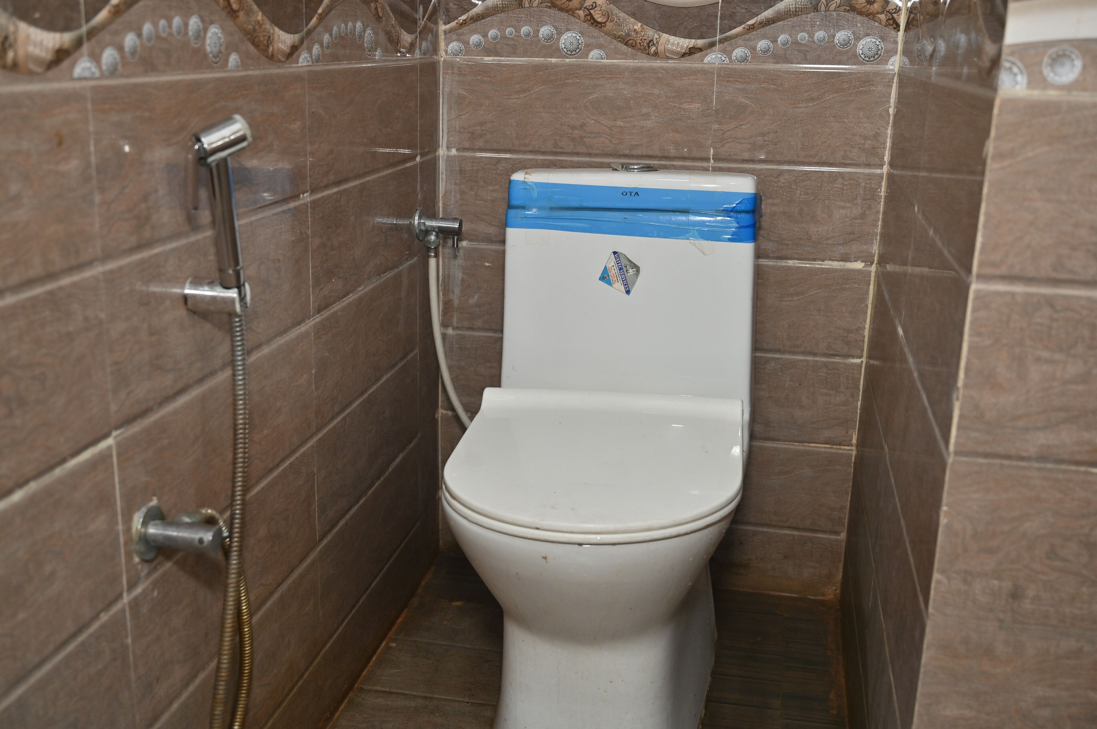 A small, tiled bathroom with a white toilet and a shower.