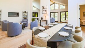 Un comedor moderno con una mesa larga preparada para seis personas, rodeada de asientos cómodos.