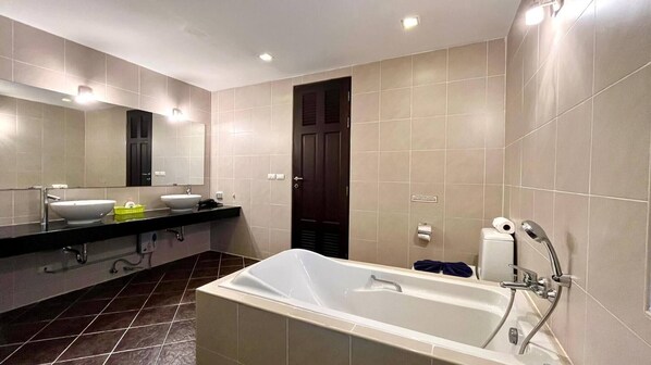 A modern bathroom with a bathtub, a sink, and a mirror.