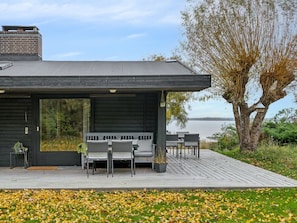 A modern house with a deck, outdoor seating, and a view of the water. - "Adelbert" - 600m to the fjord by Interhome (Jægerspris)