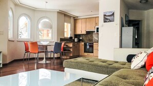 Ein modernes Apartment mit Essbereich, Küche und Wohnzimmer.