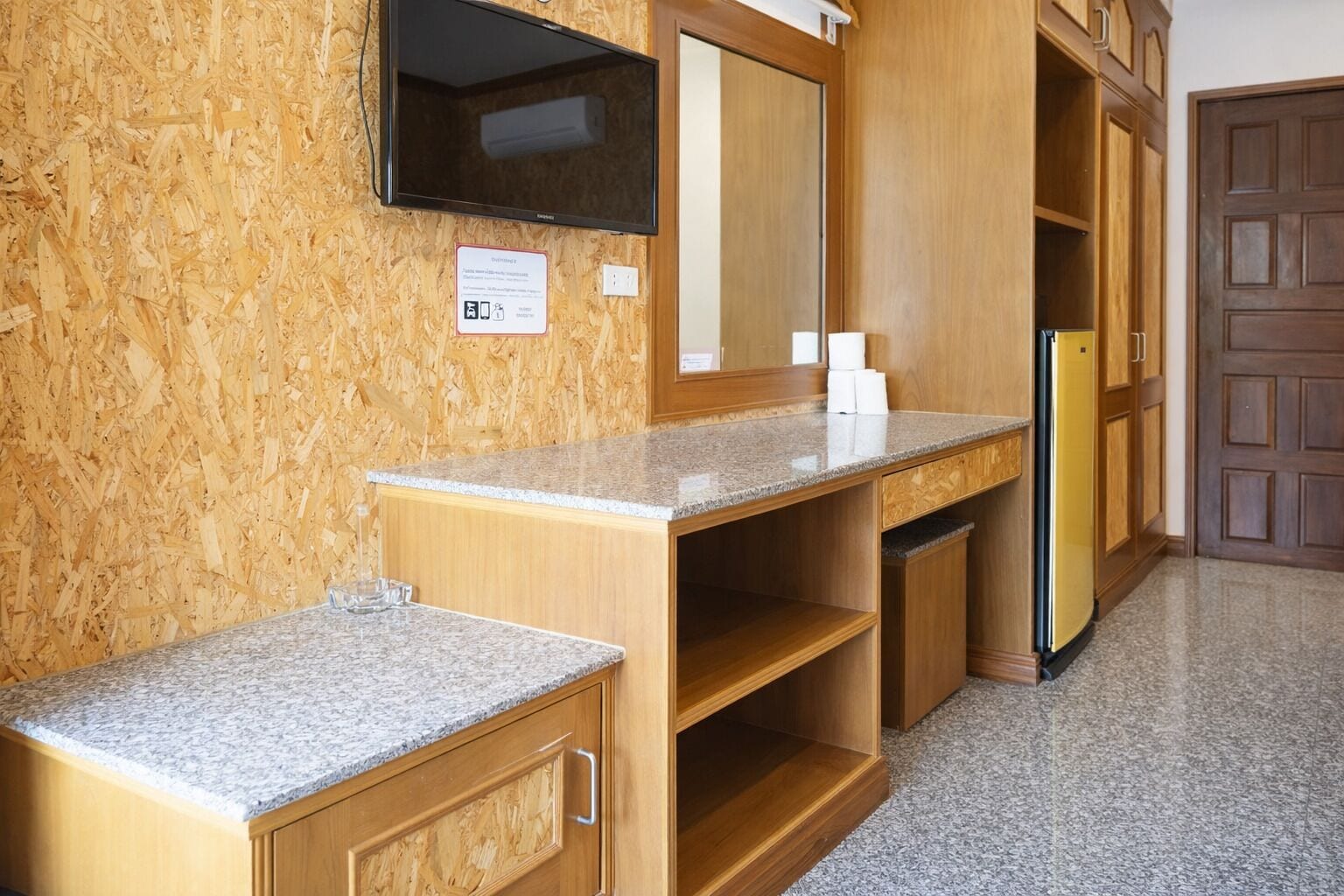 A kitchen with wooden cabinets, a granite countertop, a built-in microwave, and a refrigerator.