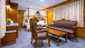 A room with a bed, a sofa, a table, and a chair. - Chatsuree Boutique Resort (Ubon Ratchathani)