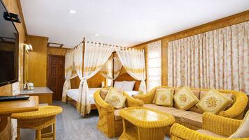 A room with a bed, a sofa, a TV, and a small table.