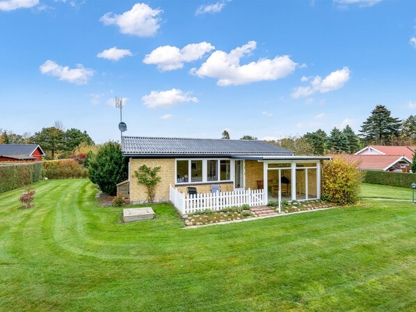 Situated in a suburban setting, this charming home features a front porch and a small garden.