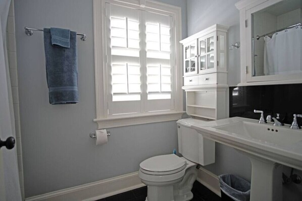Un bagno con il water, un lavandino e un armadietto.