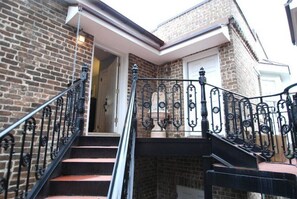 Un edificio de ladrillo con una escalera que lleva a un piso superior.