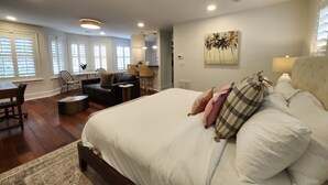 A bedroom with a large bed, a desk, and a sofa. - Carriage House B at the Hamilton House (Savannah)