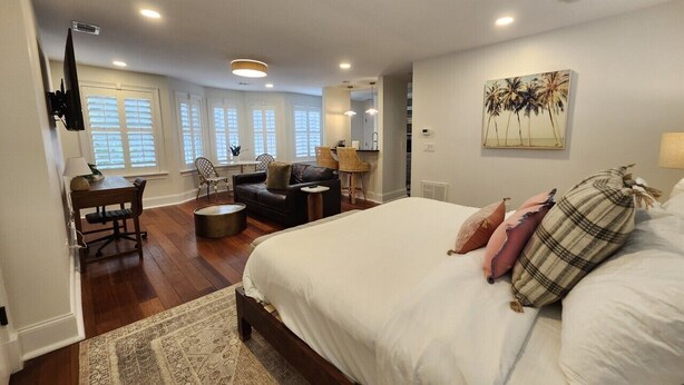 A bedroom with a large bed, a desk, a chair, and a sofa. - Carriage House B at the Hamilton House (Savannah)