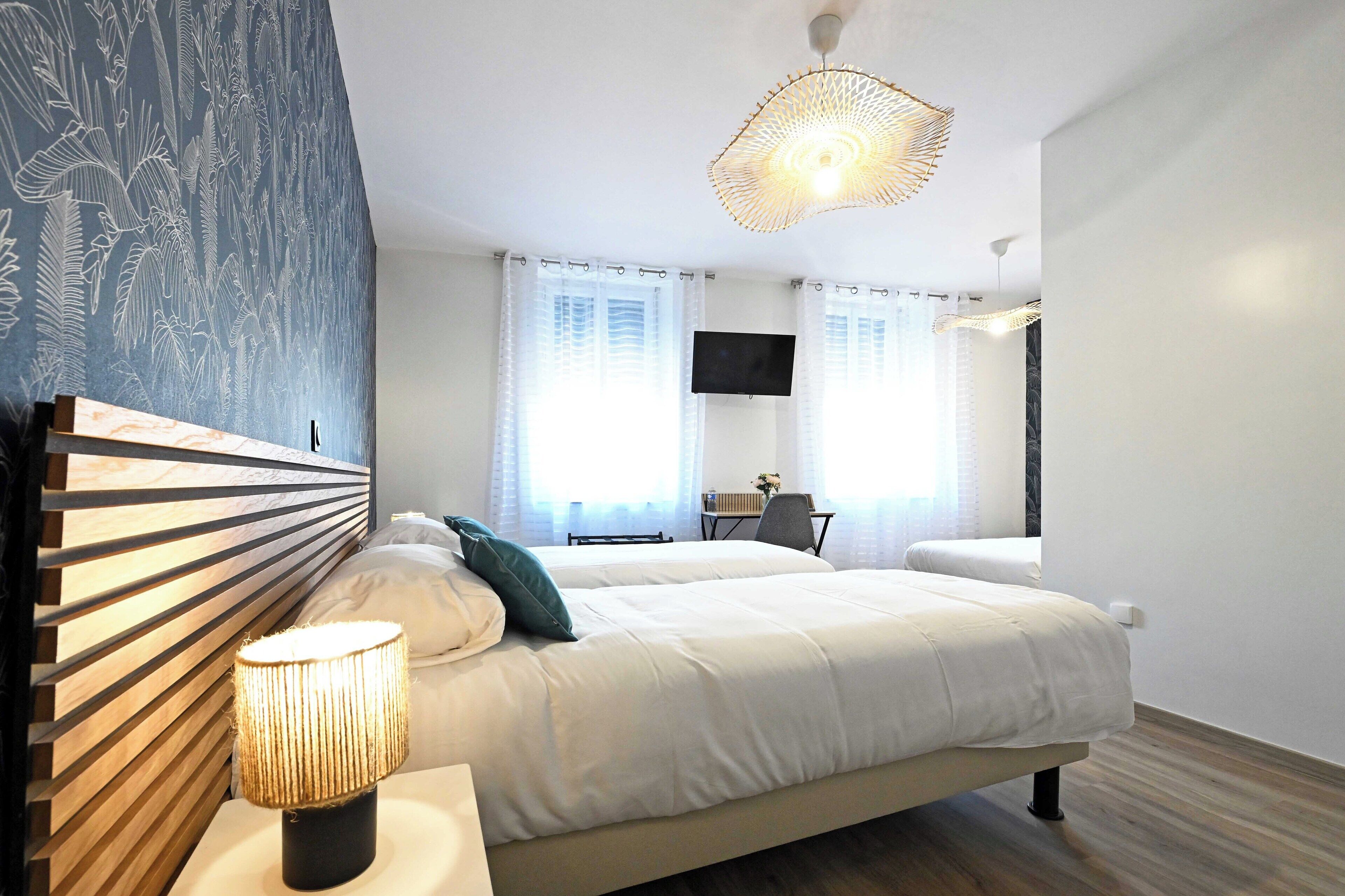 Un dormitorio moderno con una cama grande, un escritorio y un televisor.