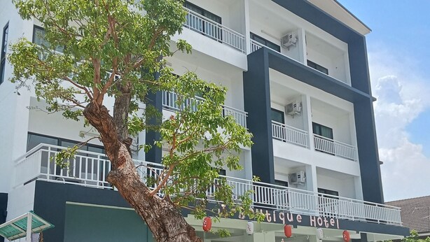 A building with a sign reading "Boutique Hotel" and a tree in the foreground. - J-Boutique Hotel (Khon Kaen)