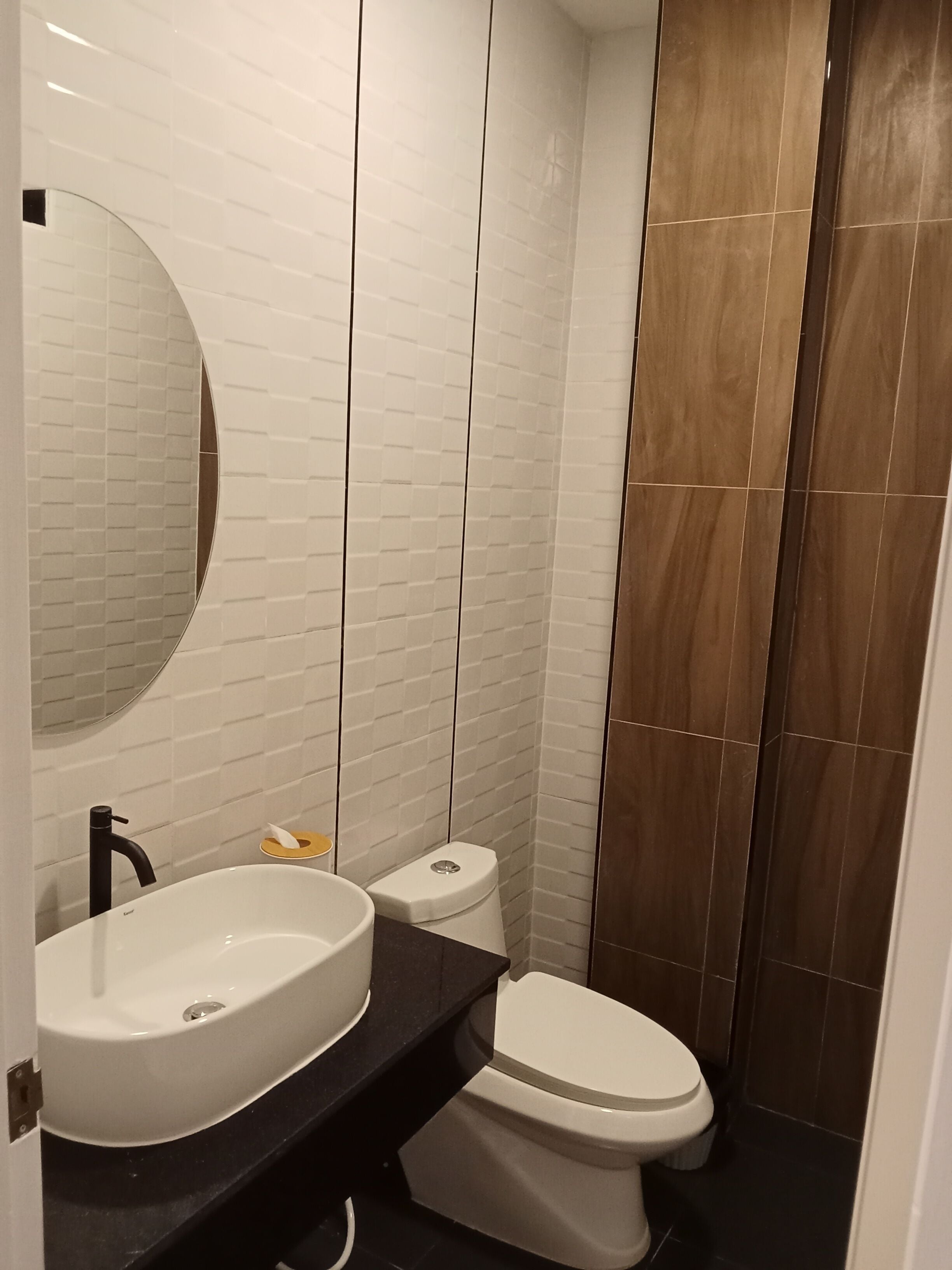A bathroom with a white sink, a toilet, and a mirror.