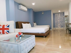 Una habitación de hotel con una cama, un sofá, una mesa de centro y un escritorio.