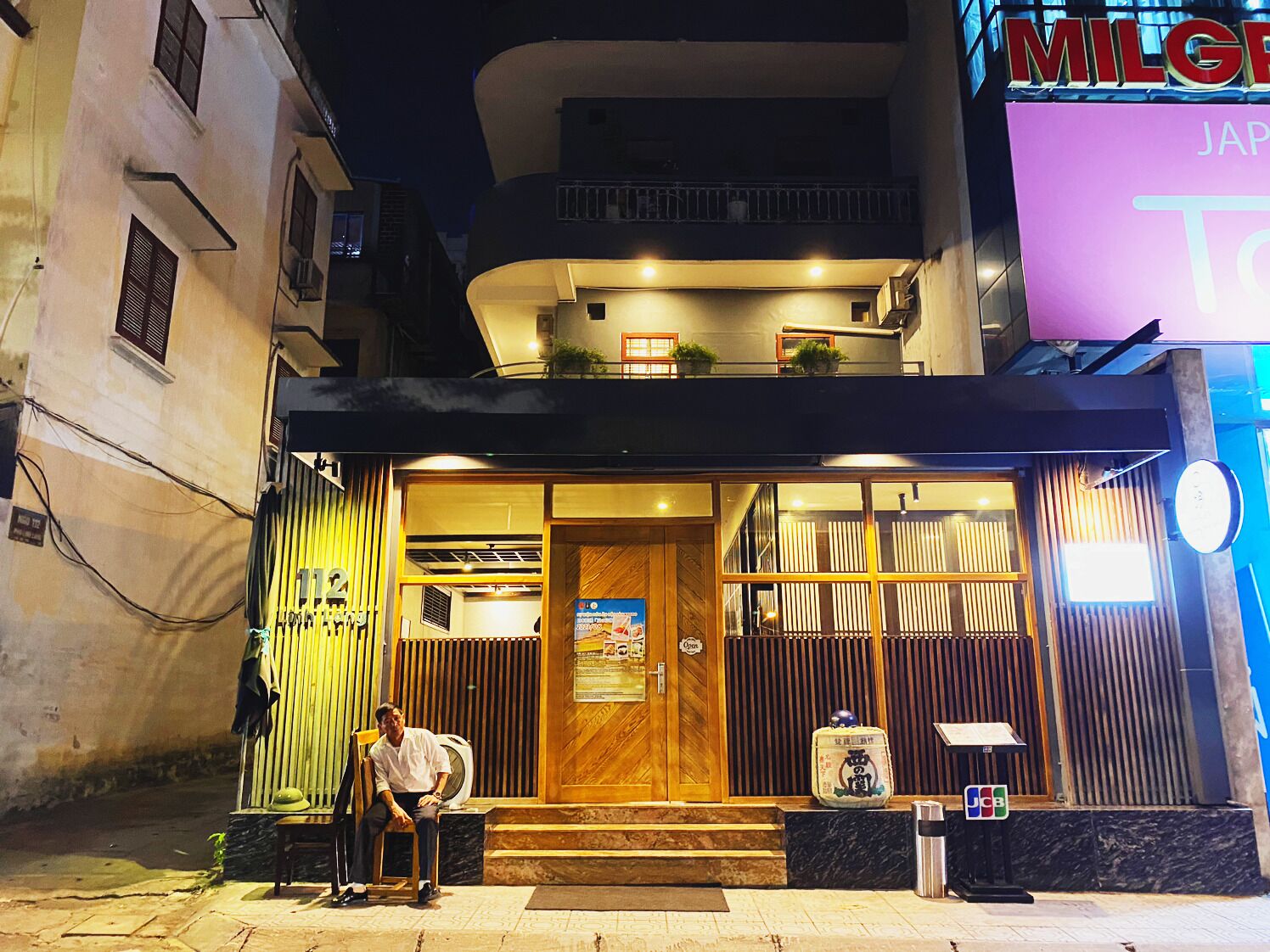 A building with a wooden door and a sign that reads "Open".