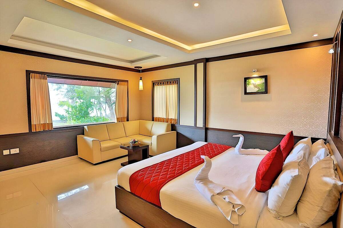 Une chambre d’hôtel moderne avec un grand lit, un canapé et une petite table.