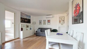 Un espacio habitable moderno con una mesa de comedor, sofá y obras de arte en las paredes.