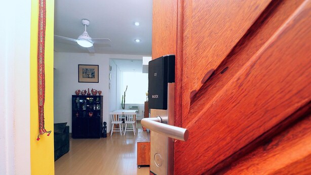 A wooden door with a modern lock and a ceiling fan in a well-lit room. - MZapartments Ataulfo Leblon (Rio de Janeiro)