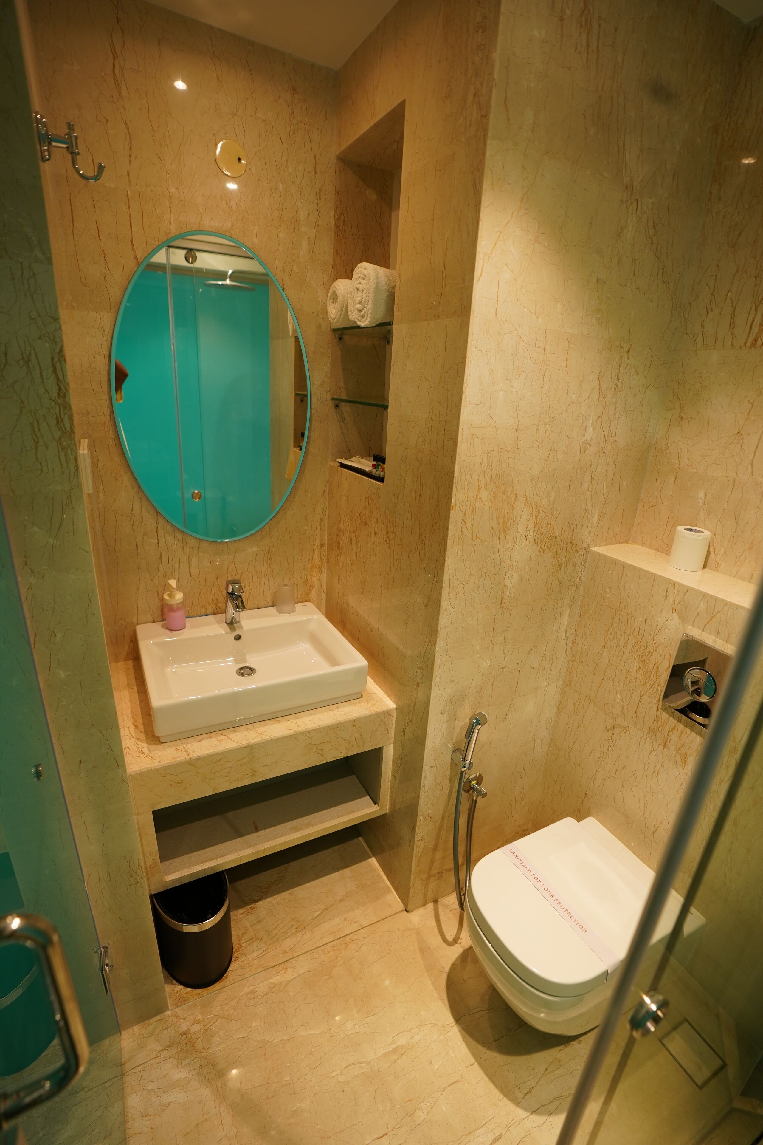 Baño con lavamanos, espejo, inodoro y ducha.