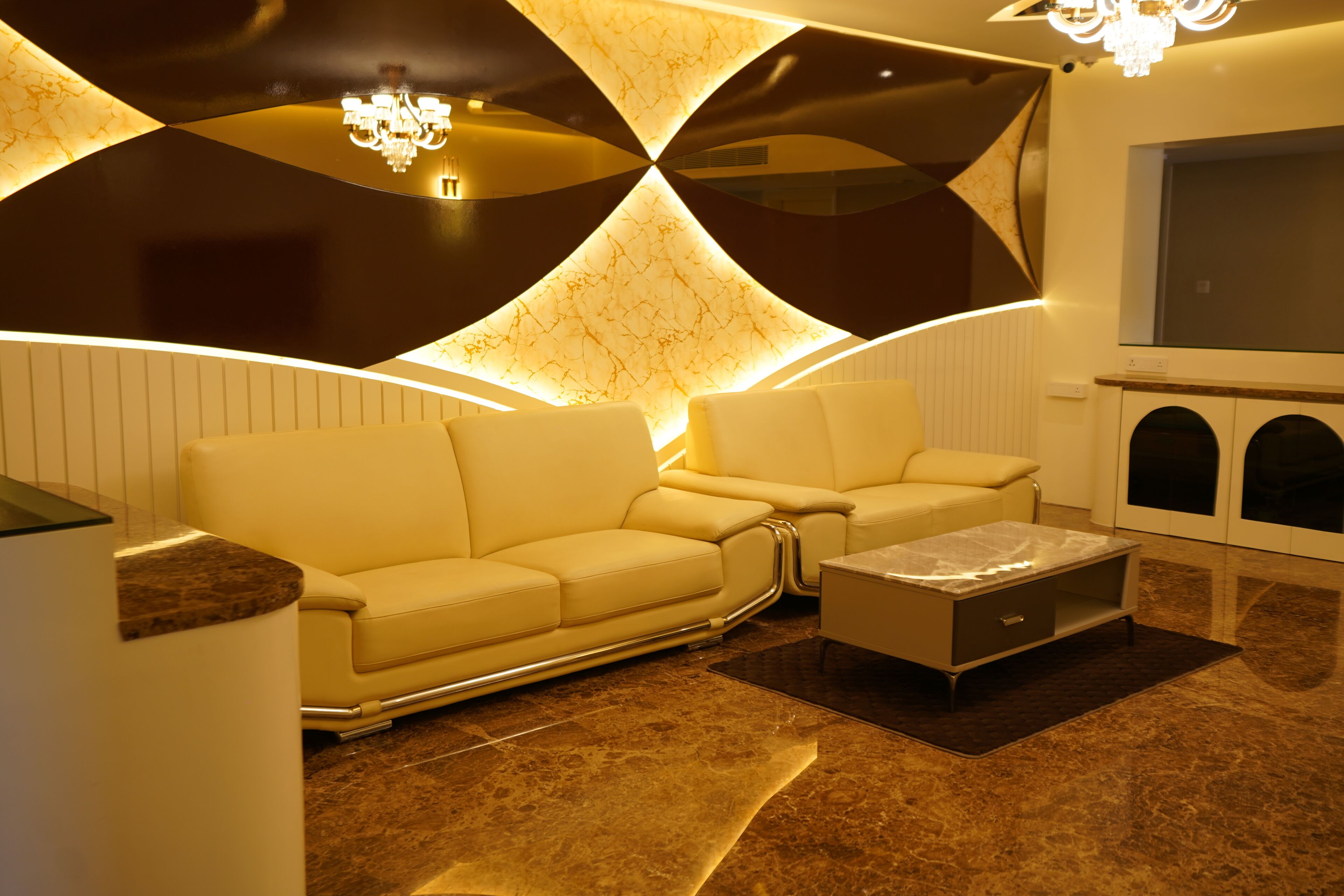 A modern living room with a sofa set, a coffee table, and a chandelier.
