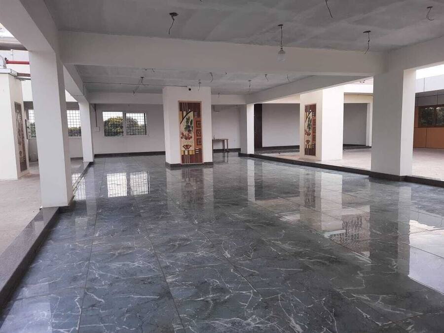 Amplio espacio interior con piso de mármol pulido, paredes blancas y ventanas grandes que dejan entrar luz natural.