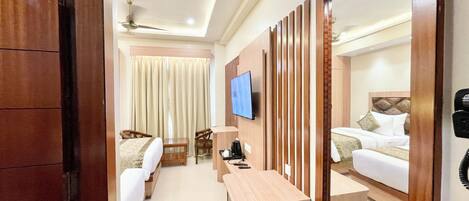 A hotel room with a bed, a desk, a chair, a TV, and a window.