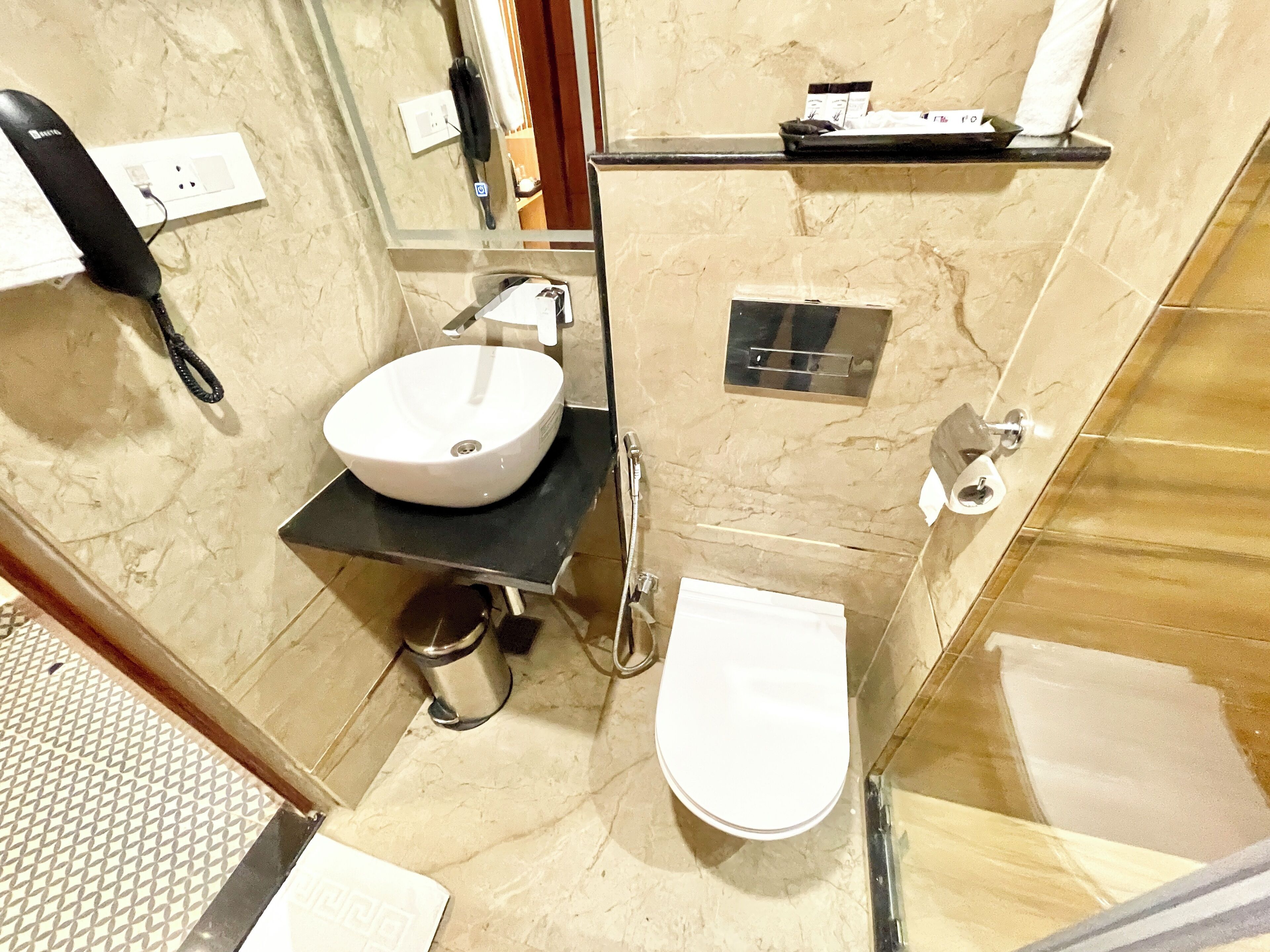 A bathroom with a white sink, a toilet, a shower, and a mirror.