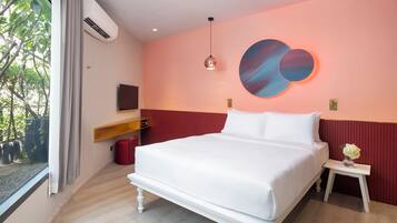 A modern bedroom with a large bed, a wall-mounted TV, and a window with curtains.