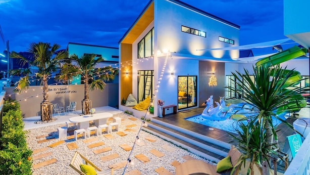 A modern house with a swimming pool, outdoor seating, and string lights. - 58-20 Pool Villa (Cha-am)