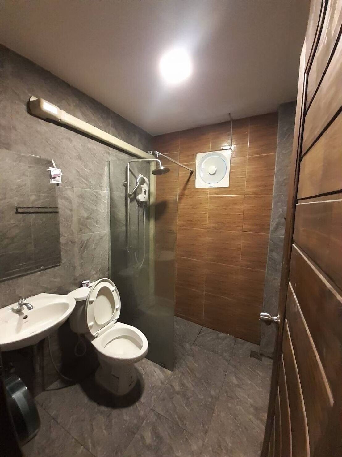 A modern bathroom with a toilet, sink, and shower.