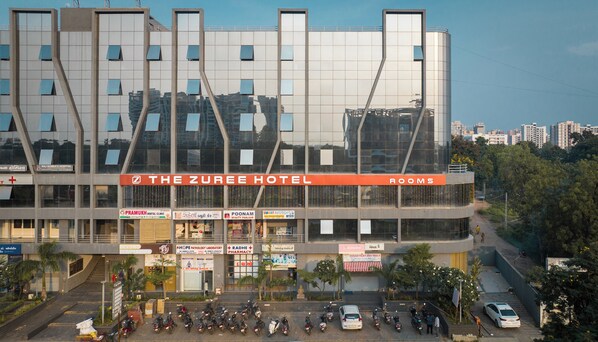 A hotel with a modern architectural design, featuring multiple floors and a prominent sign for "The Zuree Hotel." - The Zuree Hotel (Gandhinagar)