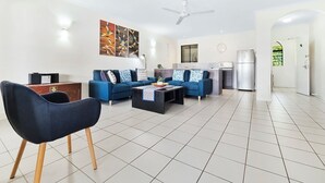 Una sala de estar moderna con un juego de sofá, una mesa de centro y un comedor con refrigerador.