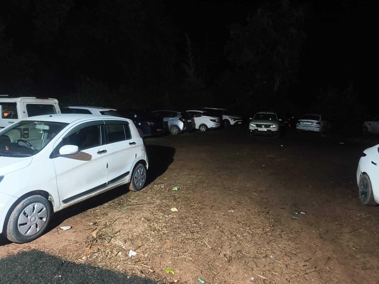 A parking lot with several cars parked, including a white SUV in the foreground.