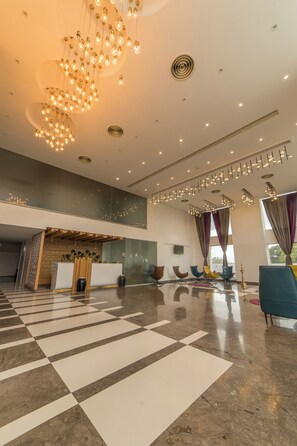 A spacious lobby with a checkered floor, a reception desk, and modern lighting fixtures. - Hotel Visakka - Palani (Palani)