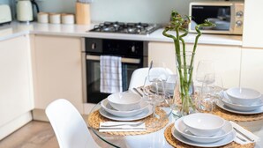 A modern kitchen with white cabinets, a gas stove, and a microwave. - Brixton/2bed Flat/privateterrace/tv/wifi (London)