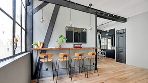 Une cuisine moderne avec un bar en bois, des tabourets de bar et des luminaires suspendus.