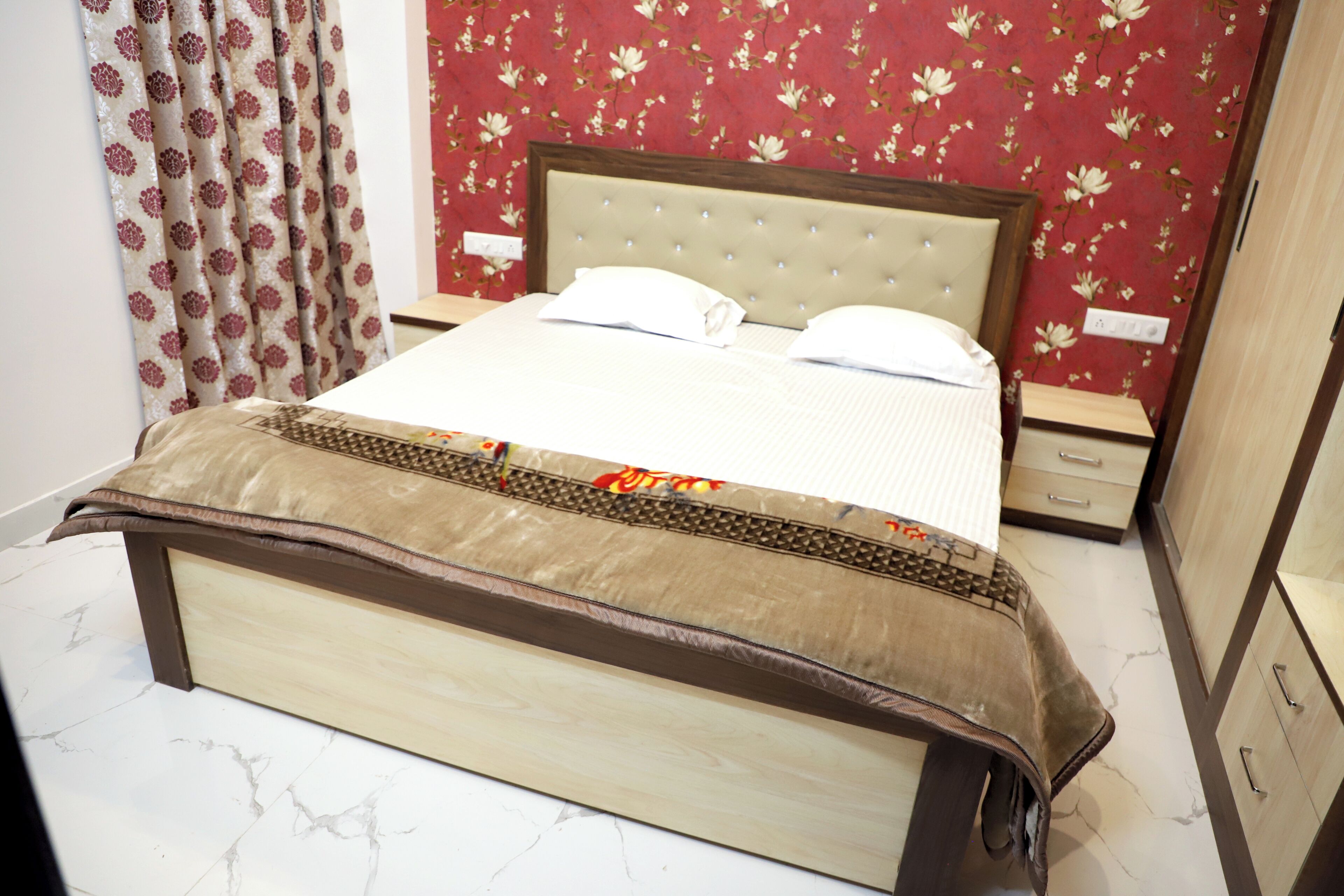 A neatly made bed with a headboard, a bedside table, and a nightstand.