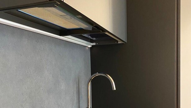 A modern kitchen with a built-in stovetop, stainless steel sink, and a sleek cabinet design. - One bedroom apartment- Bandello 22 (Milan)