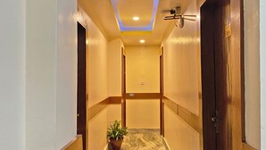 A hallway with a marble floor, wooden doors, and a ceiling with recessed lighting and a skylight. - Hotel Airport Holiday (Kathmandu)