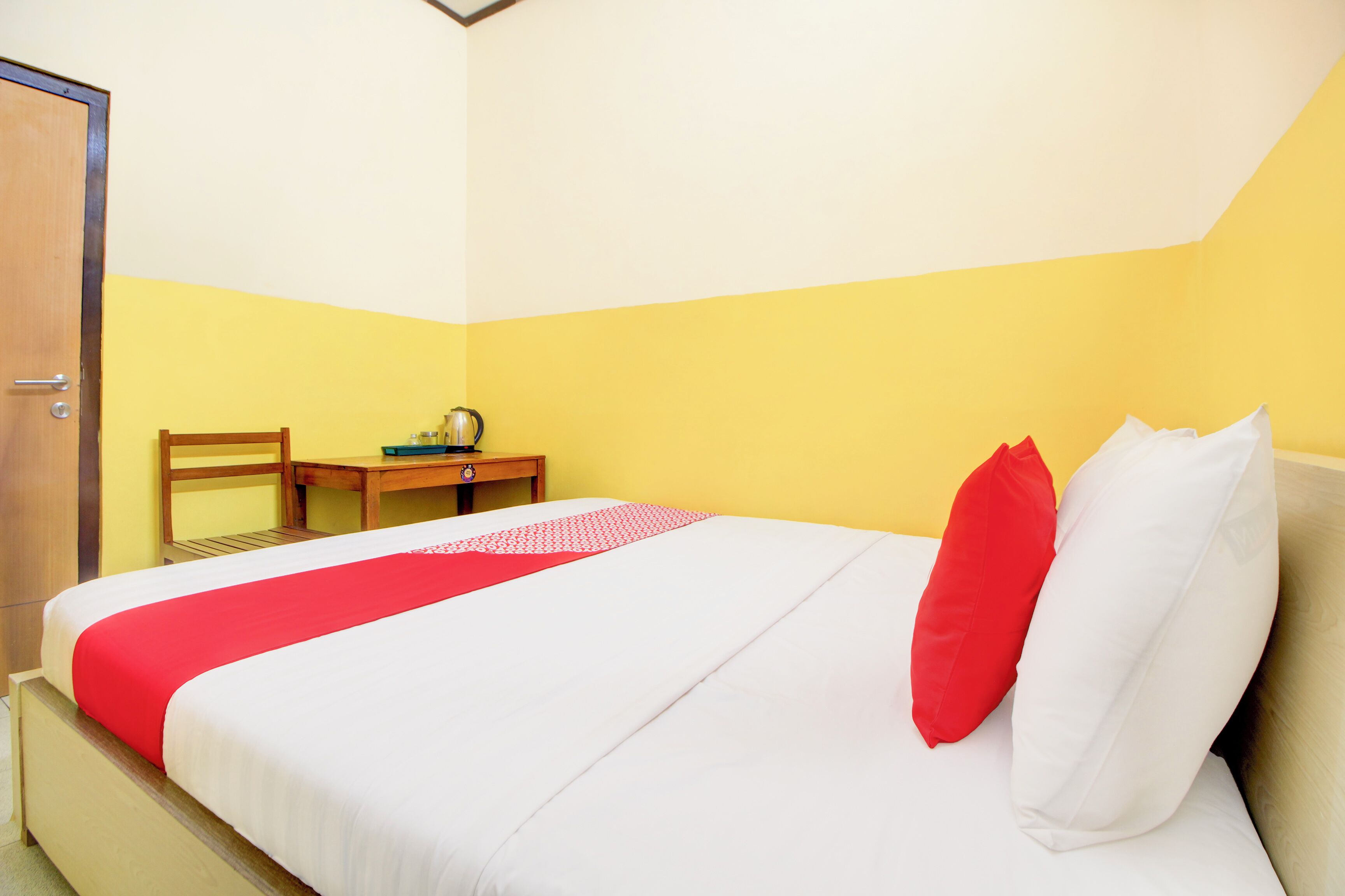 A hotel room with a bed, a desk, and a chair.