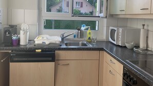 Een moderne keuken met houten kastjes, een vaatwasser, een spoelbak en een fornuis.