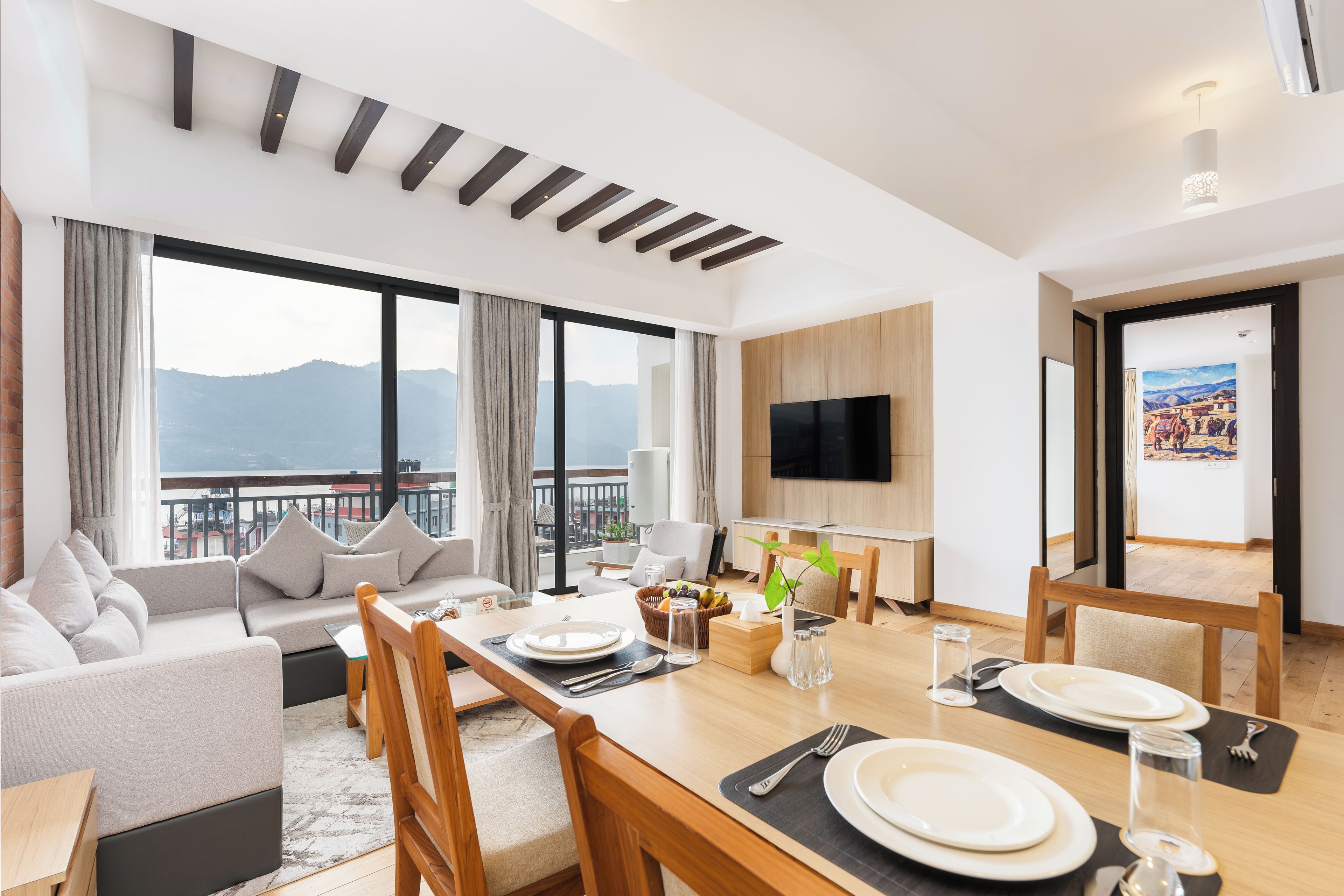 Una habitación de hotel moderna con balcón, zona de comedor y sala de estar.